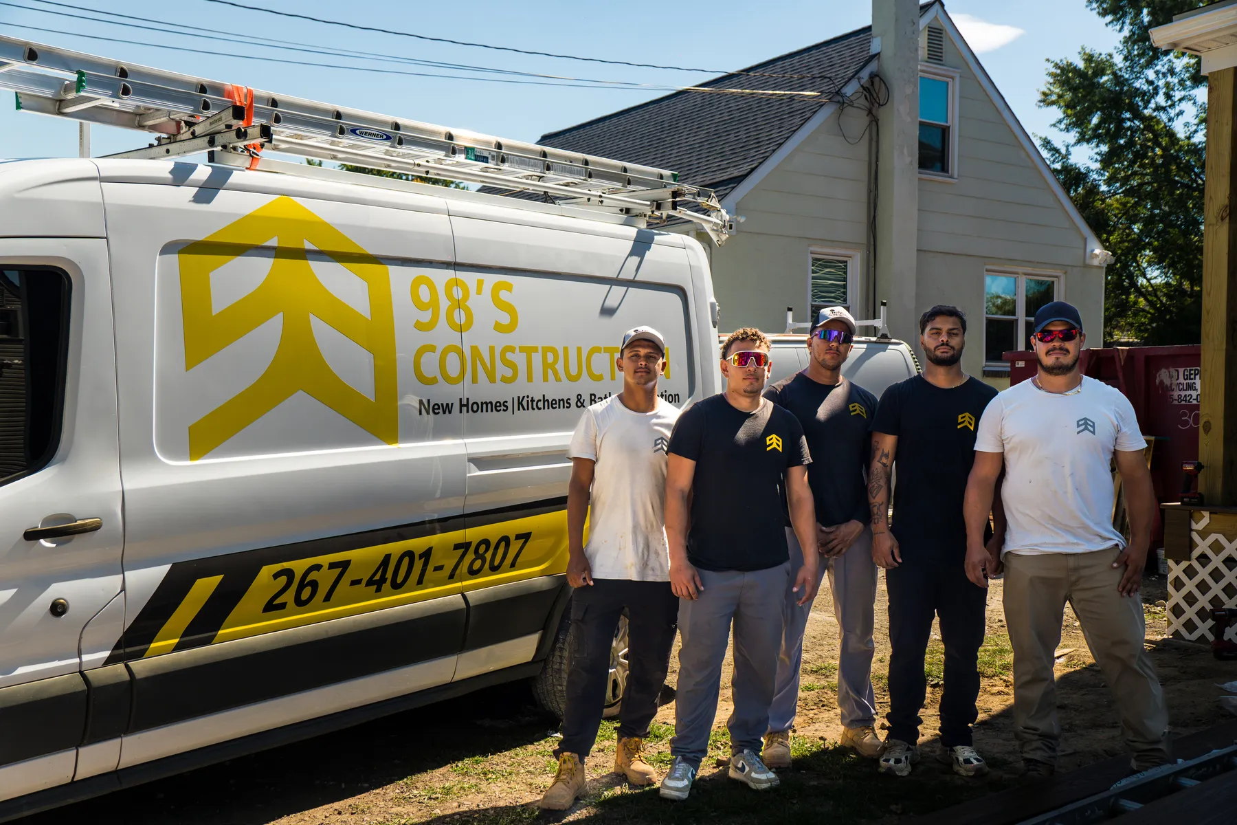 The 98's Construction crew standing beside the company van